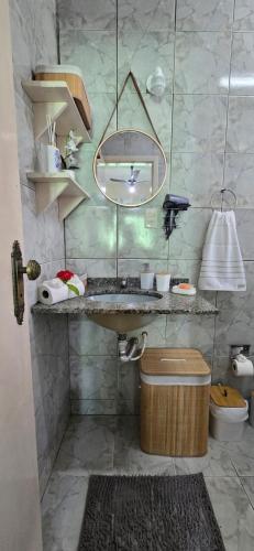 a bathroom with a sink and a mirror at Família Castro Ostras in Rio das Ostras