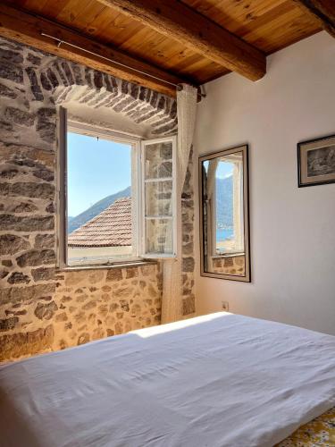 ein Schlafzimmer mit einem Bett und einem Fenster in der Unterkunft Apartments Gudco in Perast