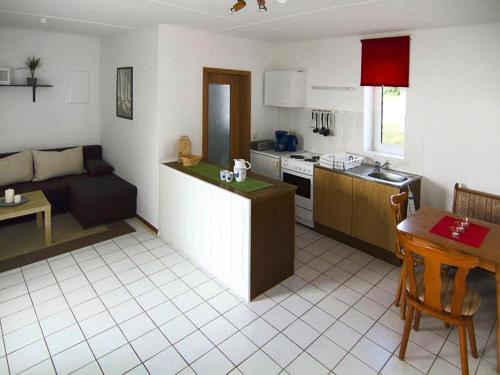 a kitchen and living room with a couch and a table at Bungalow in Klein Labenz for 4 Personen in Klein Labenz
