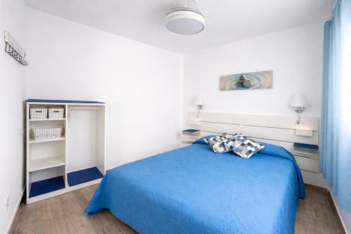 a bedroom with a blue bed in a white room at Casa Ángela in La Restinga