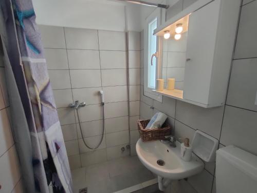 a white bathroom with a sink and a shower at kikis apartments in Drios
