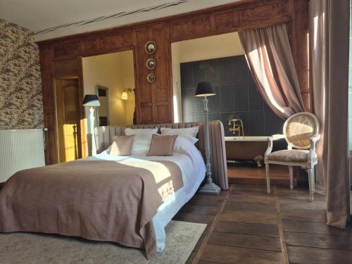 a bedroom with a bed and a tub in a room at La Bâtisse de Bromont in Bromont-Lamothe