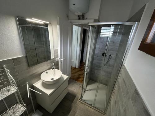 a bathroom with a glass shower and a sink at Casa Vacanza con Piscina e Accesso diretto al Mare in Santa Marinella
