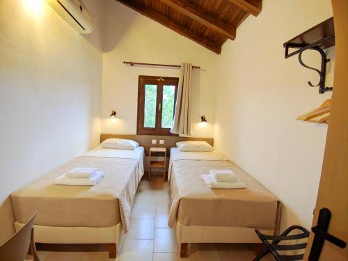 a room with two beds with towels on them at Villa Anna Maria in Agia Paraskevi