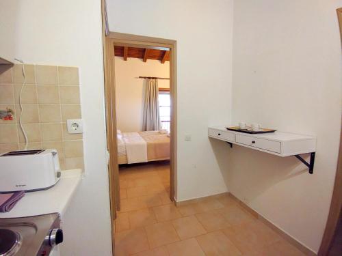 a bathroom with a sink and a room with a bed at Villa Anna Maria in Agia Paraskevi