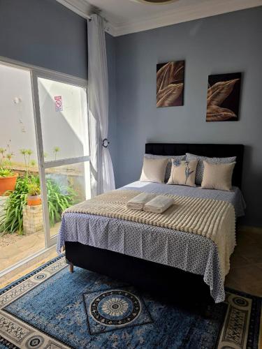 a bedroom with a bed and a large window at Hospedagem Central Curitiba - Quartos Confortáveis no Centro in Curitiba