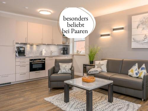 a living room with a couch and a table at See Lün 4 Sterne TOP-Fewo in Westerland Sylt strandnah zentral mit Balkon Sauna in Westerland
