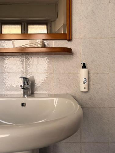 a white sink in a bathroom with a mirror at Hotel Pavone in Milan