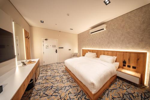 Aurion Al-Aqeeq Hotel في المدينة المنورة: غرفة فندق بها سرير وتلفزيون