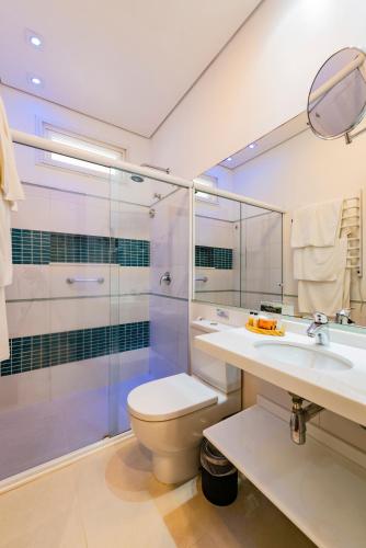 a bathroom with a toilet and a shower and a sink at Pousada Alcatrazes in Juquei