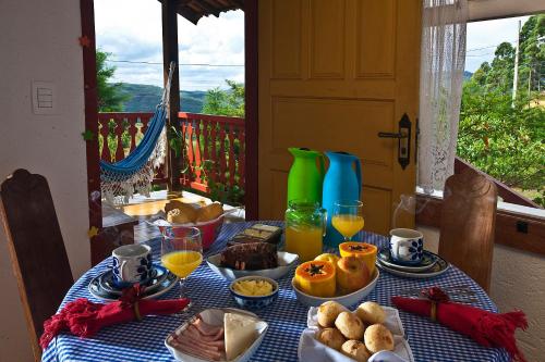 a table with a blue table cloth with food and drinks at Vila das Artes Chales in Lavras Novas