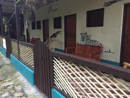 a house with a cat sitting on a porch at Zazil Ha Hostel in El Remate