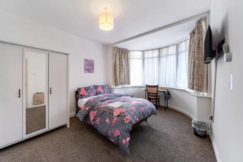 a bedroom with a bed and a desk and a window at Park 1 in London
