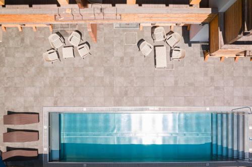 a swimming pool with chairs and lights on a wall at Saalbach Suites by ALPS RESORTS in Saalbach-Hinterglemm