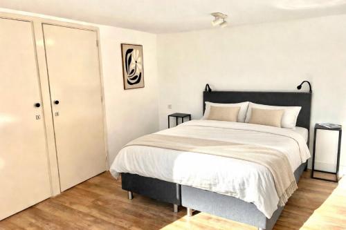 a bedroom with a large bed with white sheets at Santos in Noordwijk aan Zee