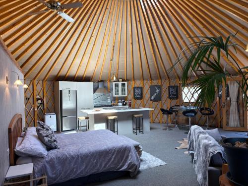 a room with a bed and a kitchen in a yurt at Riverview Yurt in Tarras