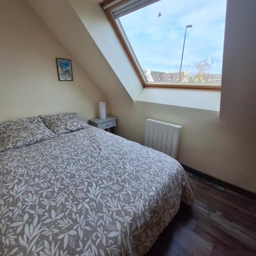 a bedroom with a bed and a large window at Ty arvor in Saint-Pol-de-Léon