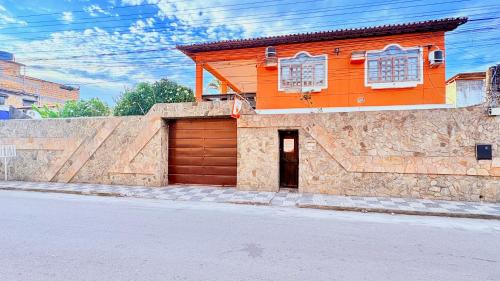 an orange house with a garage on a street at Terra do Sol Pousada e Hostel in Porto Seguro