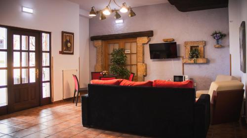 a living room with a couch and a tv at Hotel El Angliru in Cangas de Onís