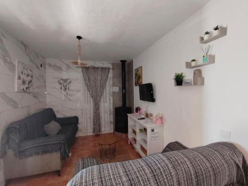 a living room with a couch and a tv at LAS TRES ROSAS in Vejer de la Frontera