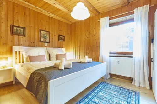 a bedroom with wooden walls and a bed with towels at Moderne Apartments im Bayerischen Wald mit Bergblick, Balkon & großer Terrasse in Schöfweg