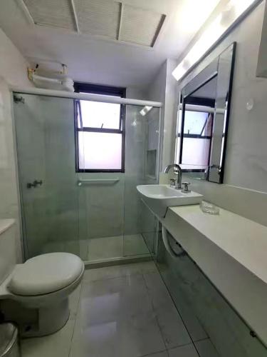 a bathroom with a toilet and a sink and a shower at Rio Hotel Reisdence in Água Boa