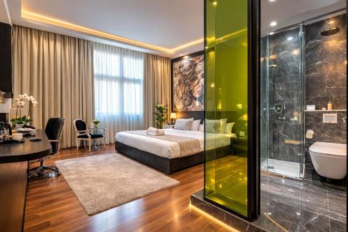 a hotel room with a bed and a bathroom at Gallery Art Hotel in Tríkala