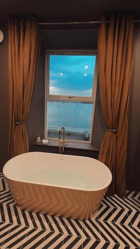 a large tub in a room with a window at MacDonald Arms Hotel in Tobermory