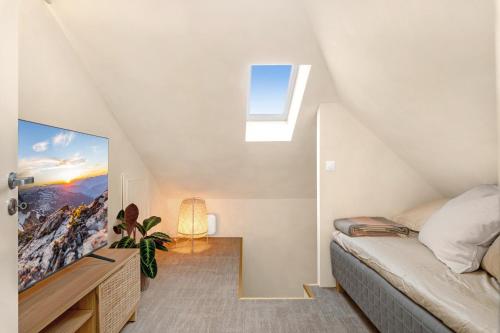 a attic bedroom with a bed and a tv at Central Apartment - Calm - No traffic in Stavanger