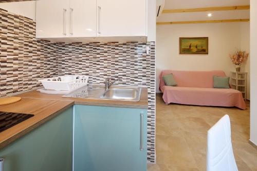 a kitchen with a sink and a couch in a room at Apartments Sonja in Šilo