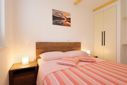a bedroom with a bed with two pillows on it at Apartments Sonja in Šilo