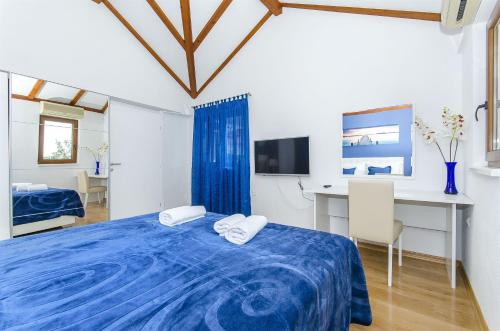 a bedroom with a blue bed and a desk at Villa Strnj in Živogošće