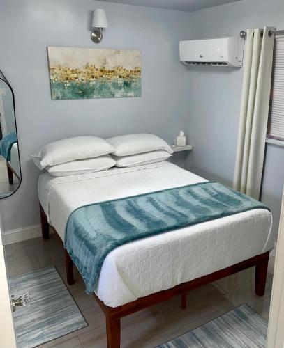 a bedroom with a bed with a blue blanket at Cozy Casarita Cottage in Miami