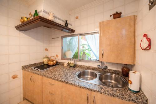 a kitchen with a sink and a window at Villa Campanilla in Olvera