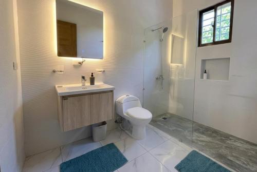 a bathroom with a toilet and a sink and a shower at Balbuena Countryside Villa with Private Pool in San Felipe de Puerto Plata