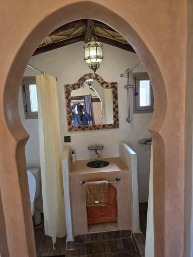a bathroom with a sink and a mirror at Riad Berber Merzouga in Merzouga