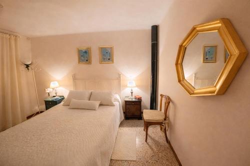 a bedroom with a bed with a mirror and a chair at Villa Campanilla in Olvera