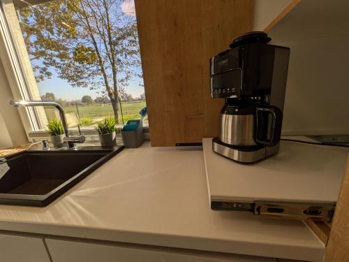 a coffeemaker sitting on a kitchen counter with a window at Chill House in Zator
