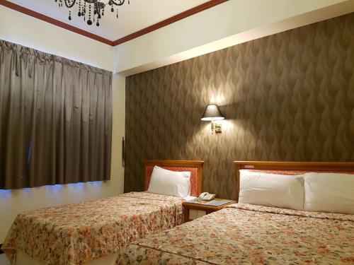 a hotel room with two beds and a phone at 凱鑫山莊 Kai Xin Hotel in Heping