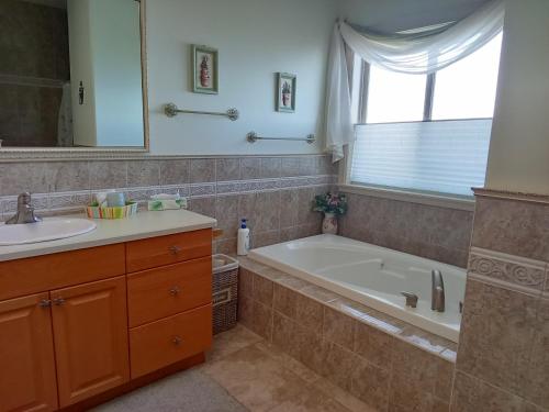 a bathroom with a tub and a sink and a mirror at Gibralter Rock Ocean View B&B in Nanaimo