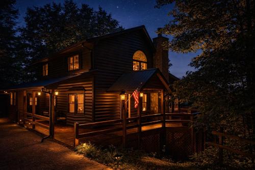 a wooden house with an american flag at night at Bella Vista! Long range MTN views, Hot Tub, Close to town and Lake in Blue Ridge