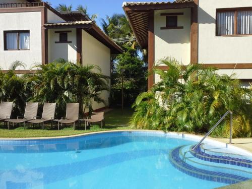 a swimming pool in front of a house at Village Lagoa do Forte in Praia do Forte