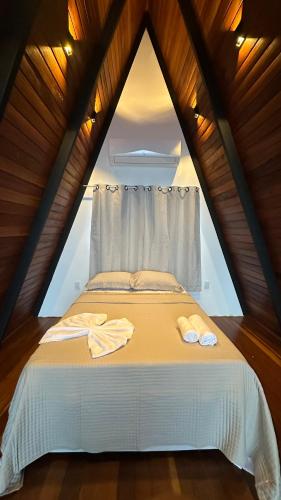a bedroom with a bed with two towels on it at Black Hut in Domingos Martins