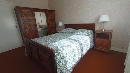 a bedroom with a bed and a dresser and a mirror at Les Collines de Compreignac in Compreignac