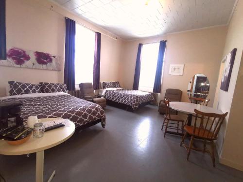 a bedroom with a bed and a couch and a table at Auberge du Couvent in Saint-Casimir