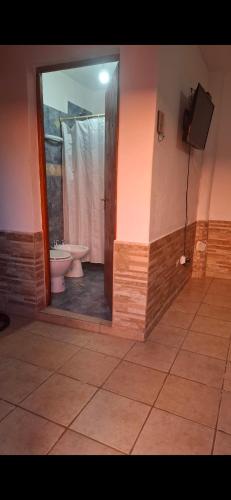 a bathroom with a toilet and a shower with a mirror at HOSPEDAJE EIMy in Purmamarca