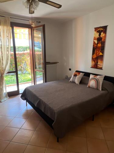 a bedroom with a large bed and a window at Casa Aurora Gardalake in Cavalcaselle