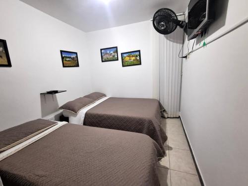 a hotel room with two beds and a flat screen tv at Apto Rincón del Café -"Piscina-Parking-8min Parque Café 321-435-21-00" in Montenegro