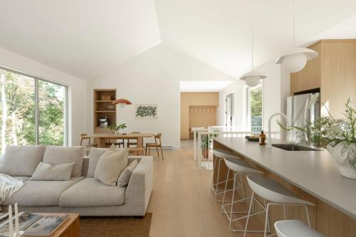 a kitchen and living room with a couch and a table at Private Nordic Spa Retreat - Mont-Tremblant in Lac-Superieur