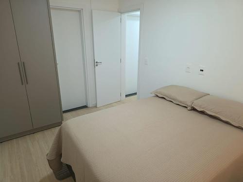 a bedroom with a bed and white cabinets at Apartamento aconchegante e tranquilo in Foz do Iguaçu